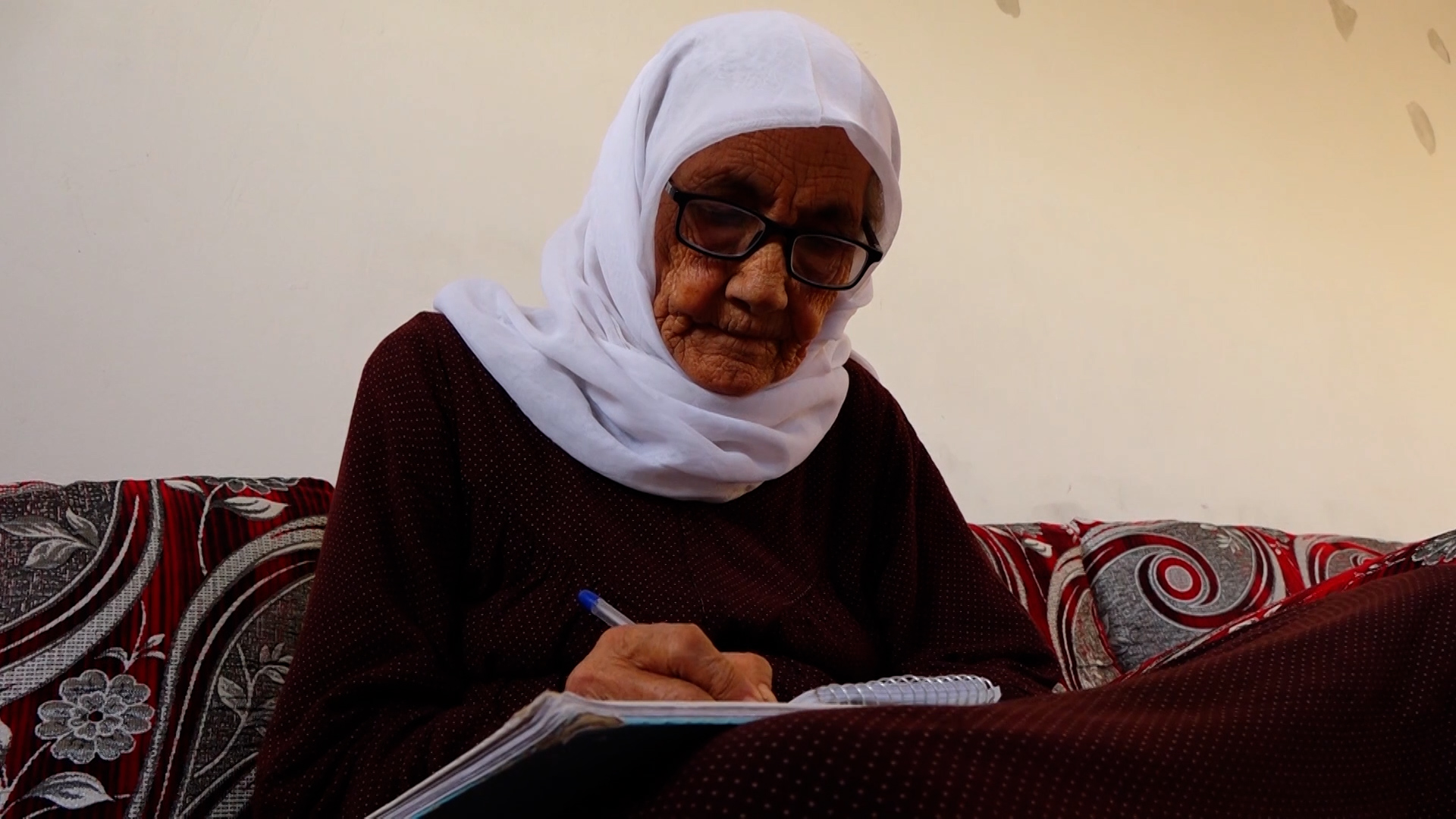رغم تجاوزها 85 عامًا.. امرأة من كوباني تستمر في ممارسة هواية الكتابة